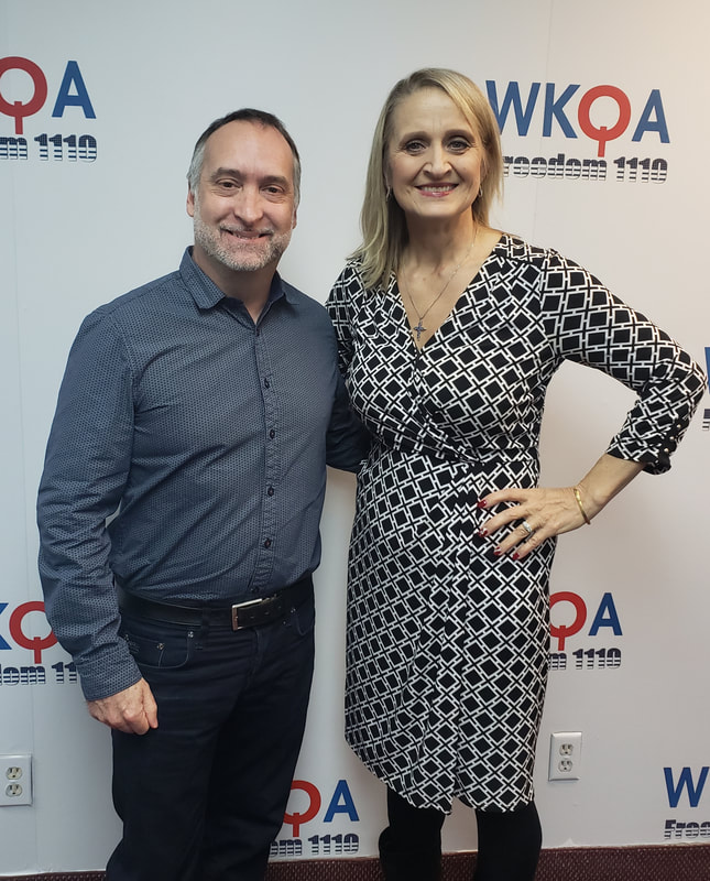 Dr. Christine Bacon and Scott Gilbert stand against the WKQA wall after another great broadcast. 