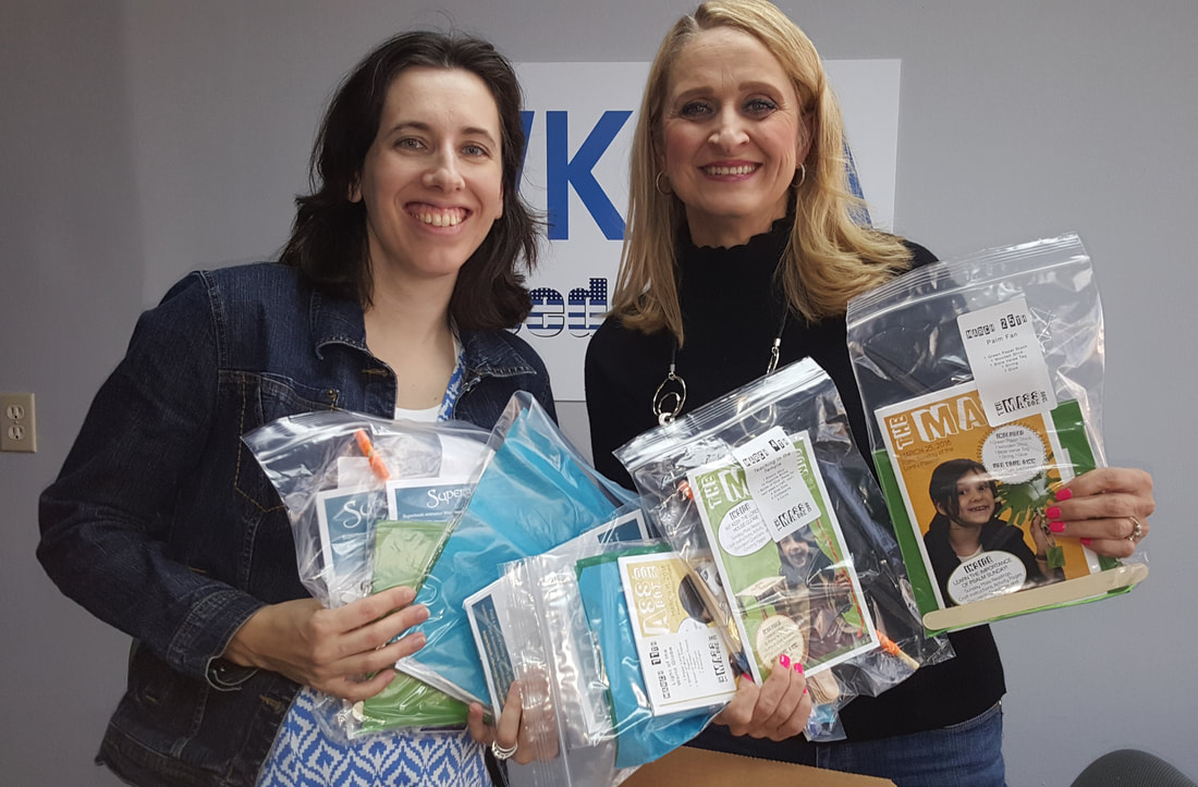Ashley and Christine holding several of the creative Mass box kits in the WKQA studios in Hampton Roads, Virginia.