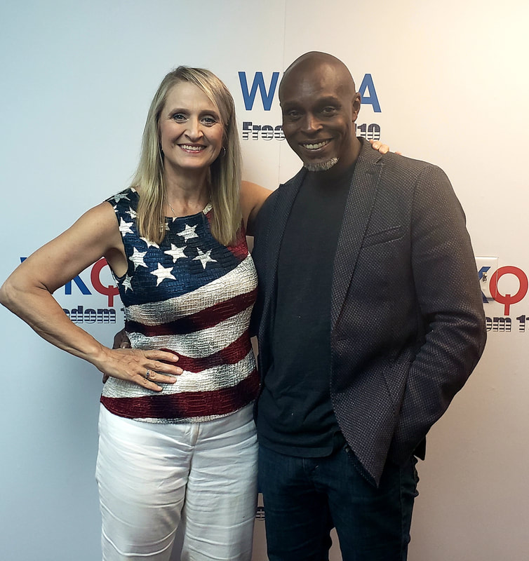 Dr. Christine Bacon and retired General Ron Lewis stand arm-in-arm in the WKQA studios in Hampton Roads, Virginia.