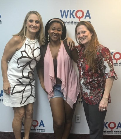 Christine Bacon, Alexis Bellamy and Jessica McCleese snuggling and smiling in the WKQA studio.