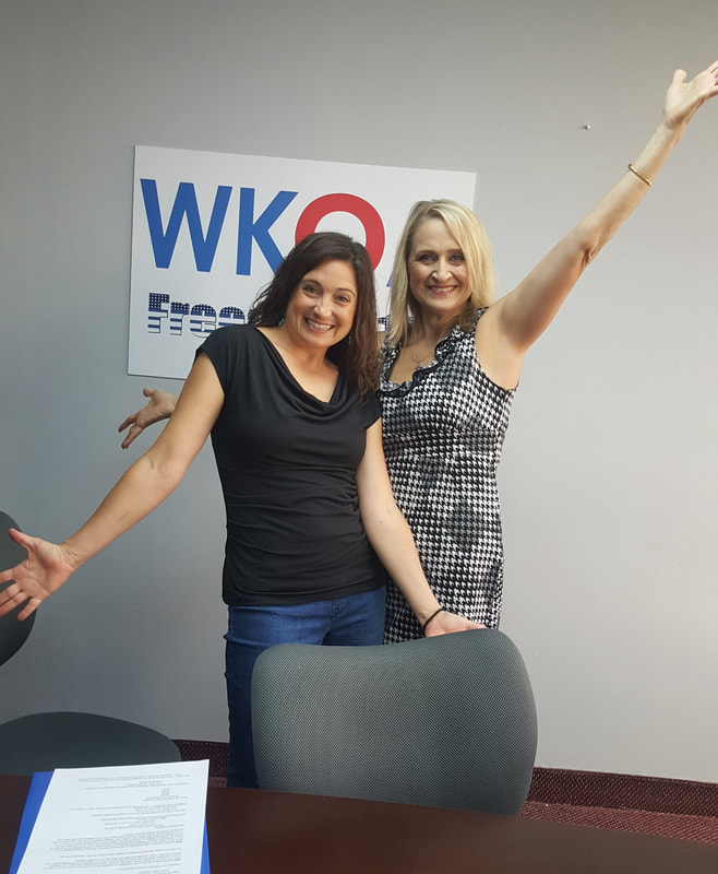Dr. Christine Bacon and guest Leslie Brown posing with spirit fingers and smiles in the WKQA studio.