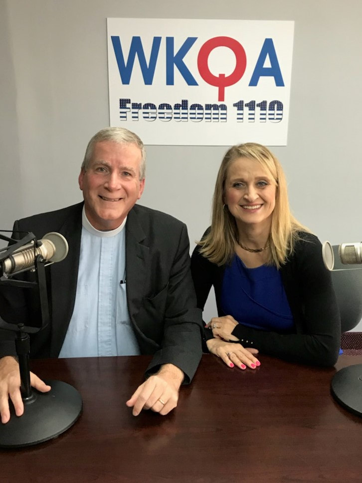 Dr. Christine Bacon and Rev. Doug Gray sit behind the WKQA radio desk in Norfolk Virginia.