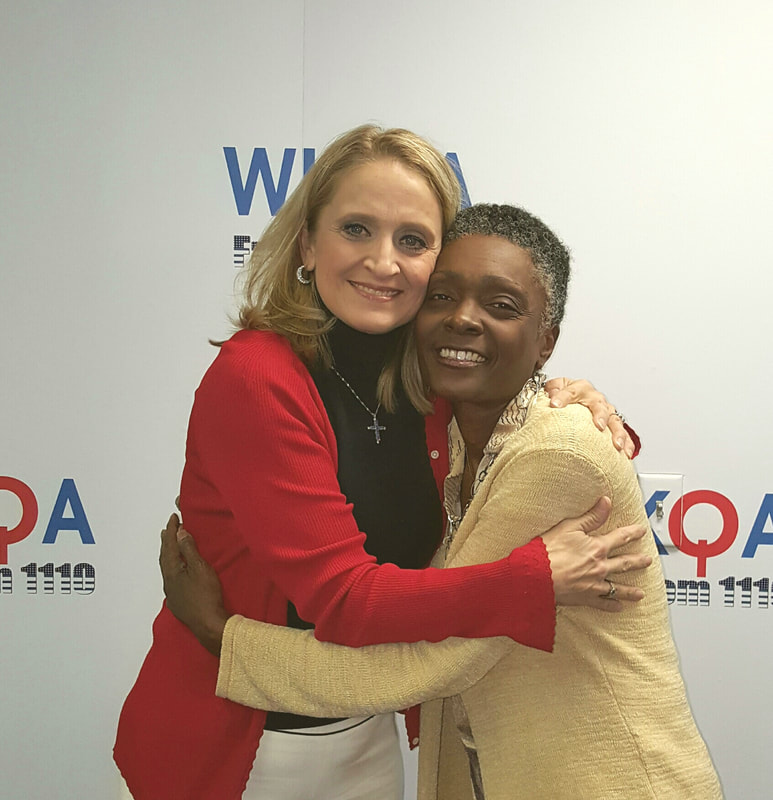 Christine Bacon and Tracey Moore sharing a hug in the WKQA studios in Hampton Roads, Virginia.